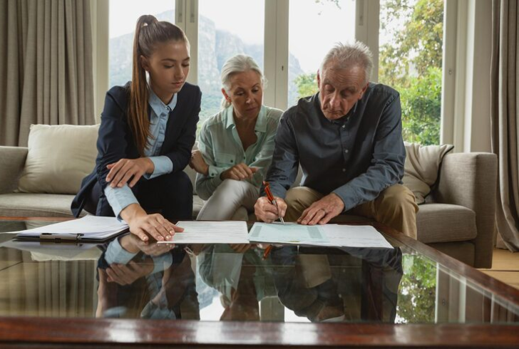 Elederly man signs papers for assisted living